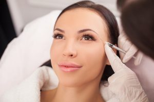 Beautiful young woman is getting botox injection at clinic