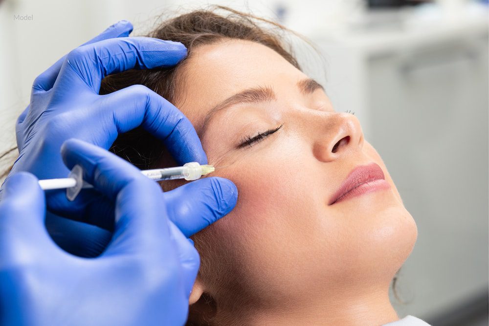 A woman undergoing facial fillers in her cheeks.