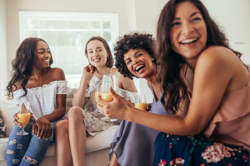 Group of female friends having a get-together in house.